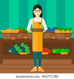 Supermarket worker with box full of apples.