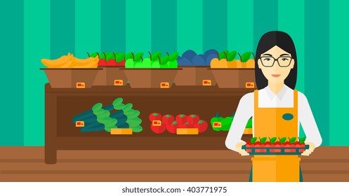 Supermarket worker with box full of apples.