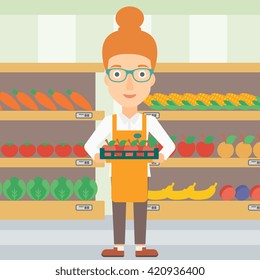 Supermarket worker with box full of apples.