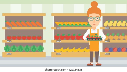 Trabajador de supermercado con caja llena de manzanas.
