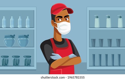 Supermarket Worker Wearing Face Mask Standing Among Shelves. Salesperson Wearing Personal Protective Equipment Working And Respecting Safety Rules During Pandemic

