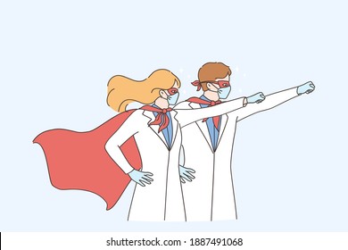 Superpower of doctors during coronavirus pandemic concept. Man and woman doctors medical workers wearing surgical face mask in superhero costume standing and raising hands up 