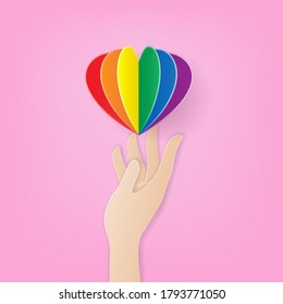 Support LGBT Pride Concept, Paper art style of hand carrying paper rainbow heart on pink background, Vector illustration