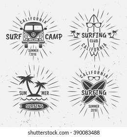 Surfing set of vector vintage typographic black labels, badges, emblems with rays, isolated on gray background with grunge texture