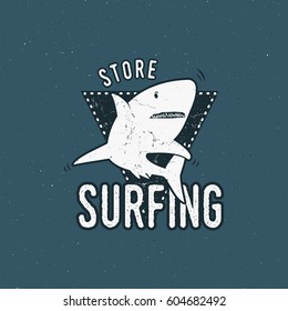 Surfing store emblem design. Shark on a triangle shield. Retro rough style. Surfing logo template isolated on blue background. Vector summer insignia.