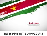 Suriname flag made in brush stroke background. National day of Suriname. Creative Suriname national country flag icon. Abstract painted grunge style brush flag background.