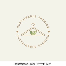 Sustainable fashion logo.Eco friendly production.Label,icon badge with clothes hanger and green leaves for natural recycling clothing,ethical fabric and slow fashion with sustainable materials.Vector