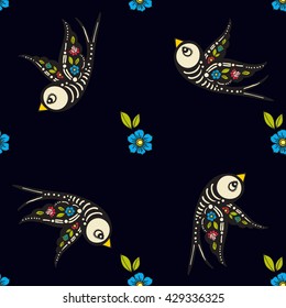 Swallows and flowers in an old-style tattoo. The day of the Dead. A seamless pattern on a black background. Texture for vintage scrapbooking, wrapping paper, textiles, web page,fashion