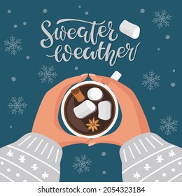 Sweater Weather calligraphy lettering and hot chocolate or coffee cup with marshmallow, cinnamon and anise. Two human hands holding cup of hot drink. Vector illustration in flat styleon dark blue