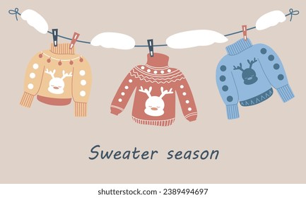 Sweaters hang on clothespins, a snowdrift on a rope. The season of winter sweaters, warmth and comfort. Warm and cozy clothes