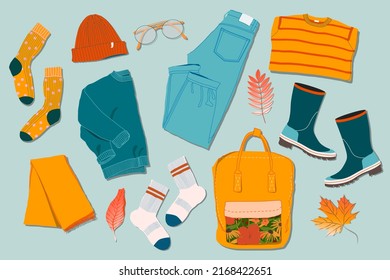 Sweaters, jeans, glasses, socks, rubber boots, leaves and backpack on a table. Trendy top down view illustration. Autumn atmosphere. Modern minimalistic group of clothes design for web card, banner.