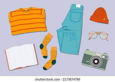 Sweaters, jeans, socks, hat, film camera, glasses and note book flat lay style. Trendy top down view illustration. Autumn atmosphere. Modern minimalistic group of clothes design for web card, banner.