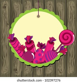 Sweets on strings with frame on the wooden background