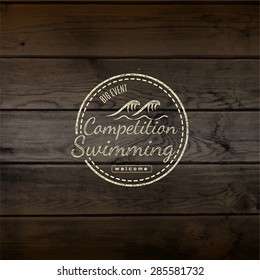 Swimming badges logos and labels for any use. on wooden background texture