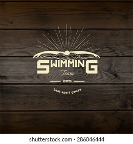 Swimming badges logos and labels for any use. On wooden background texture