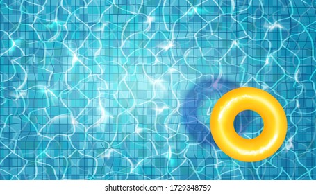 Swimming pool with floating yellow rubber ring, blue water, ripples and highlights. Texture of water surface and tiled bottom. Overhead view. Summer background.