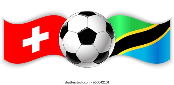 Swiss and Tanzanian wavy flags with football ball. Switzerland combined with Tanzania isolated on white. Football match or international sport competition concept.