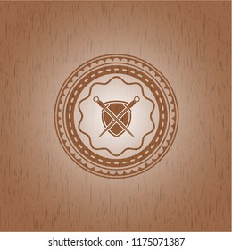 swords crossed with shield icon inside vintage wood emblem