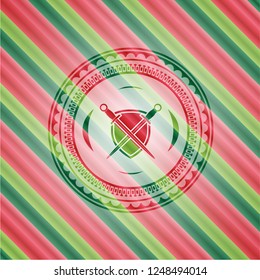 swords crossed with shield icon inside christmas colors badge.