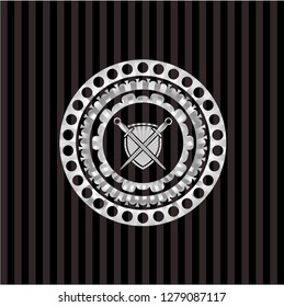 swords crossed with shield icon inside silver emblem