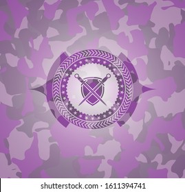 swords crossed with shield icon inside pink and purple camo emblem