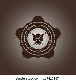 espadas cruzadas con icono de escudo dentro de placa de madera o emblema