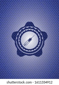 syringe icon inside badge with denim background