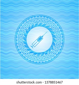 syringe icon inside light blue water wave badge background.