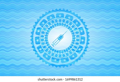 icono de la jeringa dentro del fondo de la insignia azul cielo.