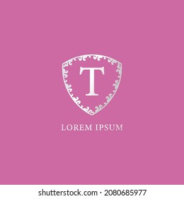 T Letter Intial logo design template. Suitable for Insurance, fashion and beauty product. Luxury silver decorative floral shield illustration. Isolated on pink color background.