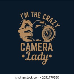 t shirt design i'm the crazy camera lady with hand holding a camera and dark blue background vintage illustration