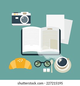 table with books, coffee, croissant, cameras and sunglasses