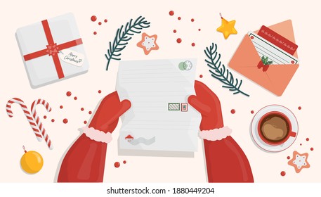 at the table with New Year's and Christmas letters Santa Claus reads letters with requests for a gift