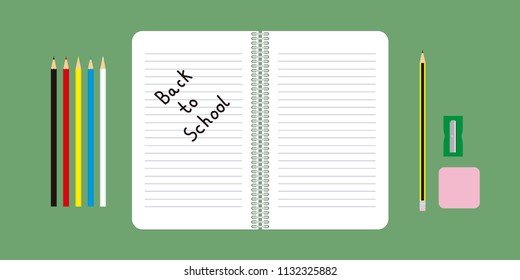 Table with a notebook, a pencil, an eraser, a pencil sharpener and colored pencils. In the notebook written the message: back to school.