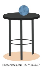 table on three legs with a ball of thread