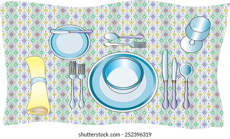 table setting with crockery and cutlery and a tablecloth