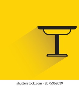 table  with shadown on yellow background