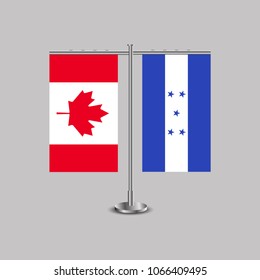 Table stand with flags of Canada and Honduras.Two flag. Flag pole. Symbolizing the cooperation between the two countries. Table flags