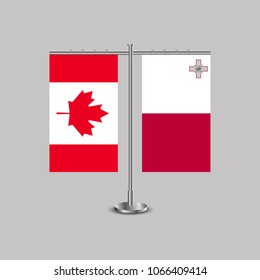 Table stand with flags of Canada and Malta.Two flag. Flag pole. Symbolizing the cooperation between the two countries. Table flags