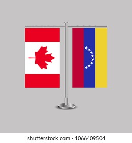 Table stand with flags of Canada and Venezuela.Two flag. Flag pole. Symbolizing the cooperation between the two countries. Table flags