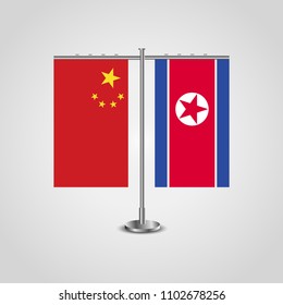 Table stand with flags of China and North Korea.Two flag. Flag pole. Symbolizing the cooperation between the two countries. Table flags