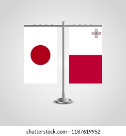 Table stand with flags of Japan and Malta.Two flag. Flag pole. Symbolizing the cooperation between the two countries. Table flags