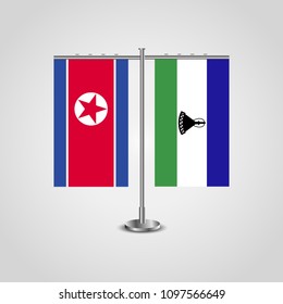 Table stand with flags of North Korea and Lesotho.Two flag. Flag pole. Symbolizing the cooperation between the two countries. Table flags