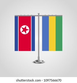 Table stand with flags of North Korea and Gabon.Two flag. Flag pole. Symbolizing the cooperation between the two countries. Table flags