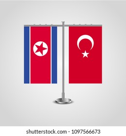 Table stand with flags of North Korea and Turkey.Two flag. Flag pole. Symbolizing the cooperation between the two countries. Table flags