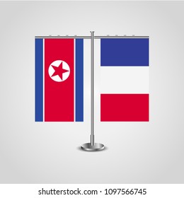 Table stand with flags of North Korea and France.Two flag. Flag pole. Symbolizing the cooperation between the two countries. Table flags