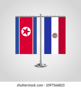 Table stand with flags of North Korea and Paraguay.Two flag. Flag pole. Symbolizing the cooperation between the two countries. Table flags