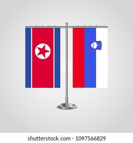 Table stand with flags of North Korea and Slovenia.Two flag. Flag pole. Symbolizing the cooperation between the two countries. Table flags