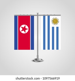 Table stand with flags of North Korea and Uruguay.Two flag. Flag pole. Symbolizing the cooperation between the two countries. Table flags