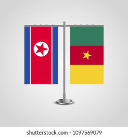 Table stand with flags of North Korea and Cameroon.Two flag. Flag pole. Symbolizing the cooperation between the two countries. Table flags